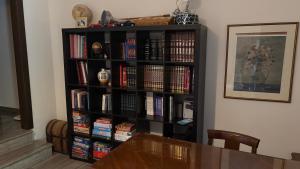 a black book shelf filled with books next to a table at Elis Studio Luxury Apartment in Ierapetra