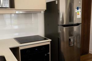a kitchen with a stainless steel refrigerator and a stove at Steps from the Shopping del Sol! in Asunción