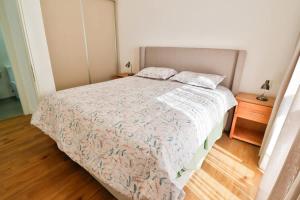 a bedroom with a bed and a wooden floor at Steps from the Shopping del Sol! in Asunción
