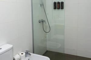 a bathroom with a glass shower with a toilet at Steps from the Shopping del Sol! in Asunción