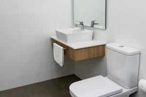 a bathroom with a white toilet and a sink at Steps from the Shopping del Sol! in Asunción +19 photos