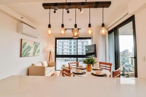 a kitchen and living room with a table and chairs at Large Apartment Just Steps from Shopping del Sol in Asunción