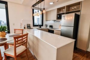 a kitchen with a white counter and a refrigerator at Large Apartment Just Steps from Shopping del Sol in Asunción