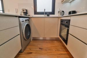 a kitchen with a washing machine and a sink at Large Apartment Just Steps from Shopping del Sol in Asunción +25 photos