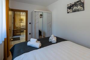 a bedroom with a bed with two towels on it at Silentium Apartment in Donji Prozor