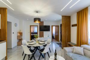 a dining room and living room with a table and chairs at Silentium Apartment in Donji Prozor
