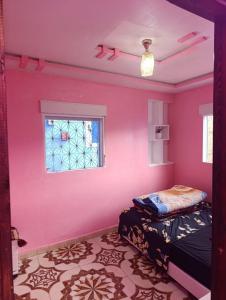 a pink room with a bed and a window at Casa Yessef Akchour in Akchour