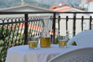 a table with a vase and two glasses on it at Penzion Sovulj SKALLA CZ in Omiš