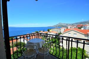 a balcony with a table and chairs and the ocean at Penzion Sovulj SKALLA CZ in Omiš