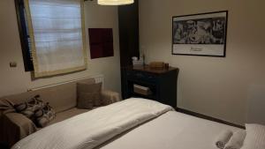 a bedroom with a bed and a couch and a window at Elis Studio Luxury Apartment in Ierapetra