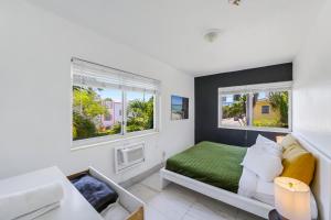a bedroom with a bed and two windows at 8040 Harding Apts in Miami Beach