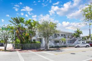 a white building with trees in front of a parking lot at 8040 Harding Apts in Miami Beach
