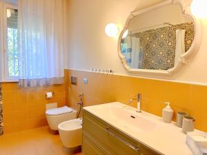 a bathroom with a sink and a toilet and a mirror at Villa Dolce Vita in San Vincenzo +27 photos