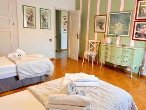 a room with two beds and a dresser with towels at Villa Dolce Vita in San Vincenzo