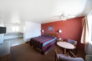 a hotel room with a bed and a table at Superior Suites Phoenix Mesa in Mesa +17 photos