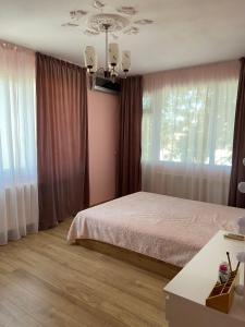 a bedroom with a bed and a large window at Emis apartment in Targovishte +4 photos