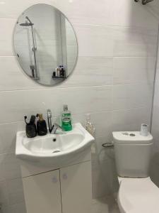 a white bathroom with a toilet and a mirror at Emis apartment in Targovishte