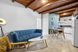 a living room with a blue couch and a table at JUNIPRO Apartments Bostalsee in Bosen-Eckelhausen