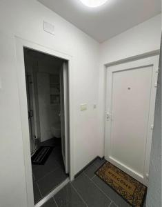 a bathroom with a door leading to a toilet at Jadranka in Vinkovci