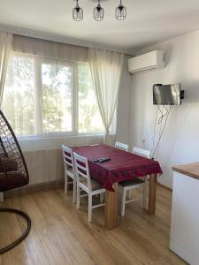 a dining room with a table and chairs and a window at Emis apartment in Targovishte