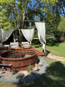 a hot tub in a yard with white drapes at Terracampo Apart in Ciudad Lujan de Cuyo