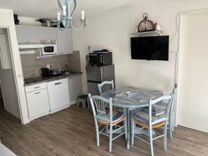 a kitchen with a table and chairs in a kitchen at Appartement 4 personnes avec terrasse Centre ville in Cauterets