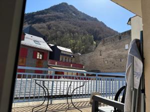 a bench on a balcony with a view of a mountain at Appartement 4 personnes avec terrasse Centre ville in Cauterets