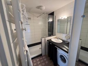 a bathroom with a sink and a washing machine at Appartement 4 personnes avec terrasse Centre ville in Cauterets