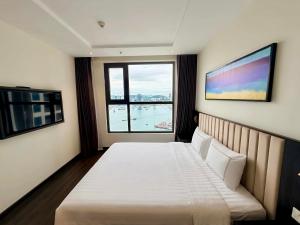 a bedroom with a white bed and a large window at Luxury Ocean View Apartments - The Sapphire Ha Long, Studio & 2BR in Ha Long +125 photos