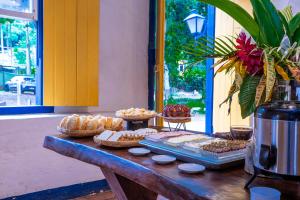 a table with different types of pastries on it at Villa Baepi Pousada Ilhabela in Ilhabela