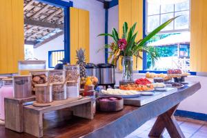 a table with many different types of food on it at Villa Baepi Pousada Ilhabela in Ilhabela