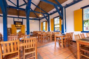 a dining room with wooden tables and chairs at Villa Baepi Pousada Ilhabela in Ilhabela