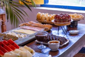 a buffet of different types of bread and pastries at Villa Baepi Pousada Ilhabela in Ilhabela