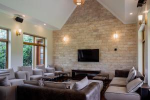 a living room with couches and a tv on a brick wall at WOODSY Resort in Nanyuki