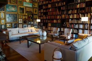 a living room with a couch and a table in a library at Quinta da Abelheira 1660 in Sobral da Abelheira