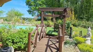 a wooden bridge leading to a garden with a gazebo at Les ptits bonheurs, maison proche de St-Emilion in Frontenac