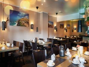ein Restaurant mit Tischen und Stühlen und einem Gemälde an der Wand in der Unterkunft Hotel Hafentor in Hamburg