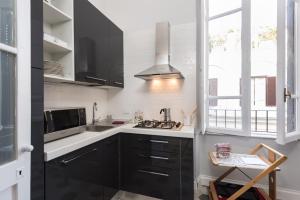 a kitchen with black cabinets and a sink at Casa Minerva Al Pantheon in Rome