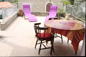 a table and chairs on a patio with purple chairs at Studio de la maison Lilas in Pila-Canale