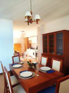 a dining room table with plates and wine glasses at Alojamento Local Velas Balcony in Velas