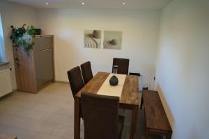 a dining room with a wooden table and chairs at Ferienwohnung Mangfalltal in Bruckmühl +6 photos