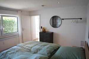 a bedroom with a bed and a mirror and a dresser at Ferienwohnung Mangfalltal in Bruckmühl