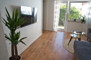 a living room with a couch and a tv on a wall at Ferienwohnung Mangfalltal in Bruckmühl