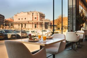 a table and chairs on a balcony with a view of a city at Van der Valk Hotel Spa in Spa