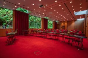 a conference room with tables and chairs on a red carpet at Van der Valk Hotel Spa in Spa +44 photos