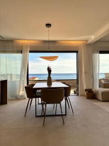 a dining room with a table and chairs with a view of the ocean at Penthouse Jacuzzi SeaView Suite in Makarska