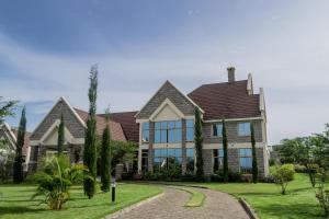 a large house with a pathway in front of it at WOODSY Resort in Nanyuki