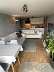 a living room with a white couch and a table at Apartament Ostrzyce in Ostrzyce