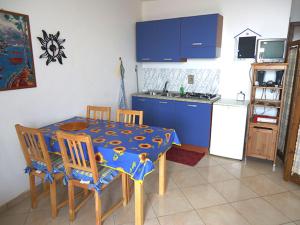 a kitchen with a table and chairs and blue cabinets at Spiaggia Grande Poseidon Beach Resort in Casa dello Stumio