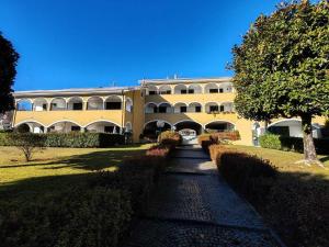 a large yellow building with a pathway in front of it at Spiaggia Grande Poseidon Beach Resort in Casa dello Stumio +2 photos